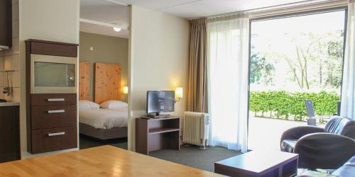 een hotelkamer met een bed en een televisie bij Appartementen Bad Boekelo in Enschede
