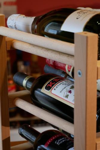 a bunch of wine bottles on a wooden shelf at Hotel Rodovoli in Konitsa