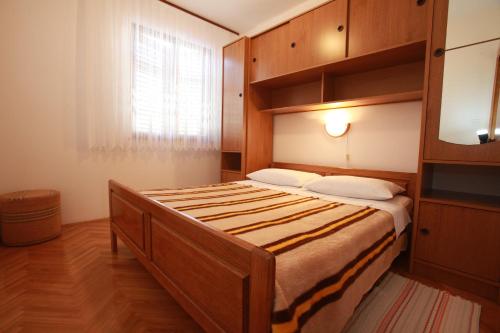 sypialnia z dużym łóżkiem i drewnianą szafką w obiekcie Apartments Nada w Bašce