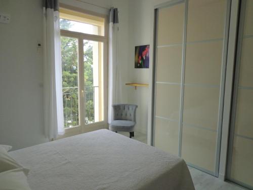 a bedroom with a bed and a window and a chair at Domaine Les Rivales in Cavaillon
