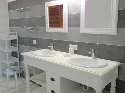 uma casa de banho com 2 lavatórios e um espelho em Domaine Les Rivales em Cavaillon