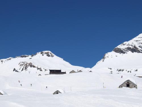 a ski lodge in the snow with mountains in the background at Walser App.31 Pozzi in Bosco Gurin