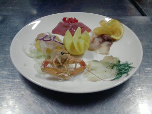a plate of food with seafood and vegetables on a table at Hotel Kursaal in Passignano sul Trasimeno
