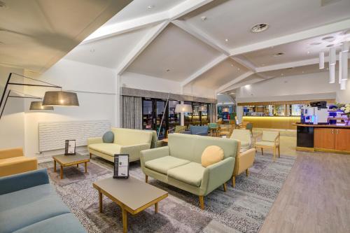 a waiting room with couches and chairs and tables at Warwick Conferences - Radcliffe in Coventry