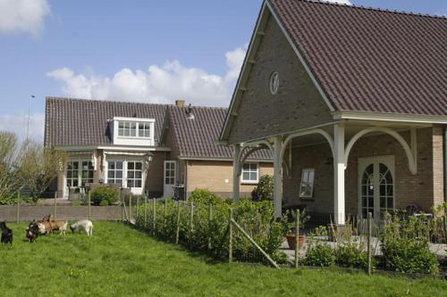 a house with three animals standing in the yard at Het Jaarsveldhof in Montfoort