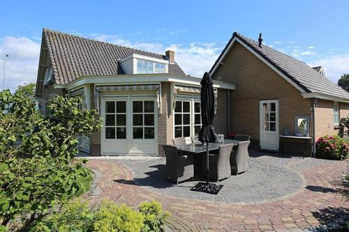 a house with a patio with a table in front of it at Het Jaarsveldhof in Montfoort