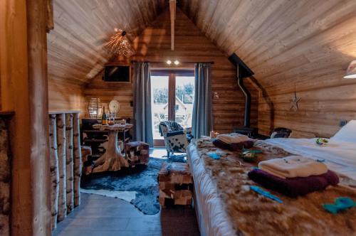 Un dormitorio con dos camas en una cabaña de madera. en Aqualodge Hôtel Insolite, en Ermeton-sur-Biert