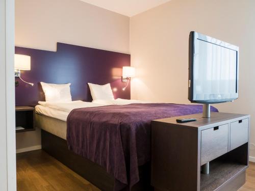 a hotel room with a bed and a flat screen tv at Finn Apartments in Lund