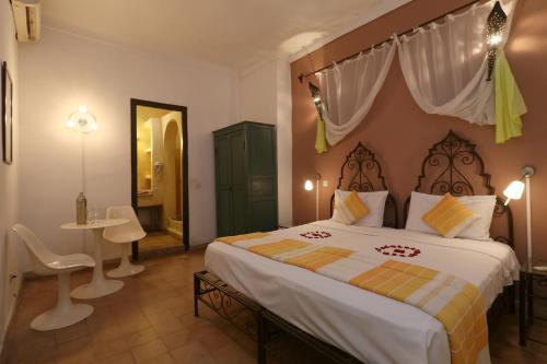 a bedroom with a large bed and a table at Riad Alwane in Marrakech