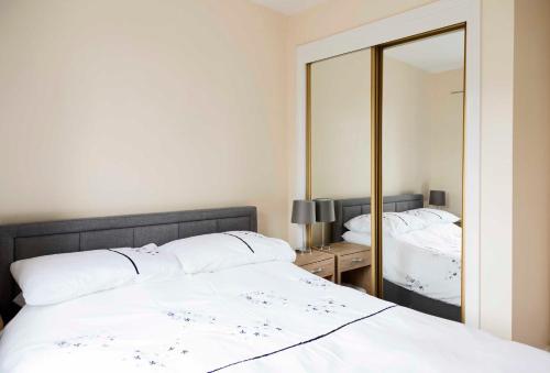 a bedroom with a bed and a large mirror at Stewarton apartments in Stewarton