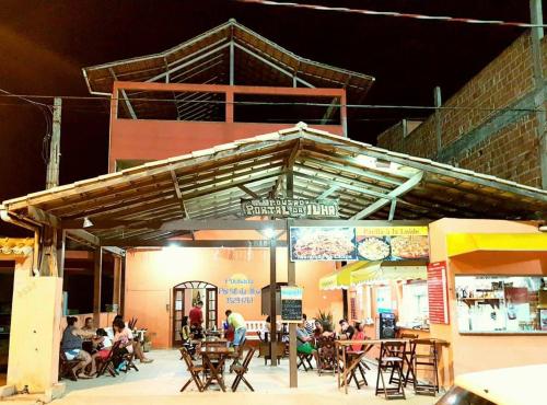 a group of people sitting at tables in a restaurant at Pousada Portal da Ilha in Itaoca