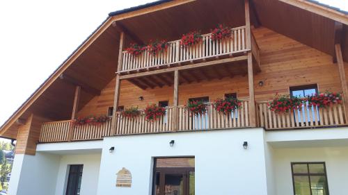 a building with a balcony with red flowers on it at Chata u Tří Sluk in Modrava