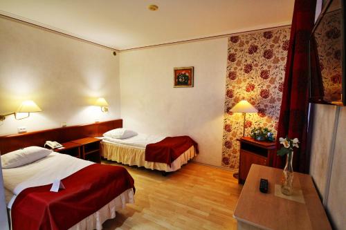 a hotel room with two beds and a table at NB Hotel with Free Parking in Rīga