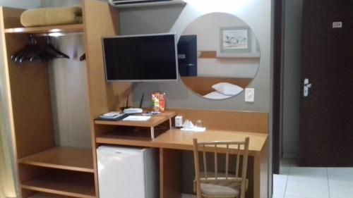 a room with a desk with a computer and a mirror at Vila Verde Hotel in Toledo