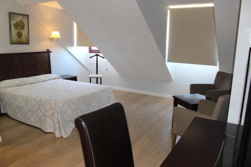 - une chambre avec un lit, un canapé et une chaise dans l'établissement Apartahotel Villa de Parla, à Parla
