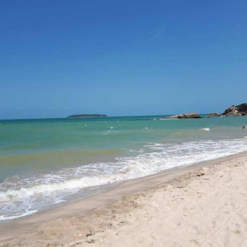 a sandy beach with the ocean in the background at Pousada Portal da Ilha in Itaoca