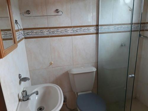 a bathroom with a toilet and a sink and a shower at Pousada Casa D` Guio in Rio das Ostras