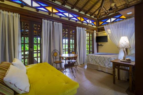 a bedroom with a bed and a table and chairs at Paraty Villa d`agua Temporada in Paraty