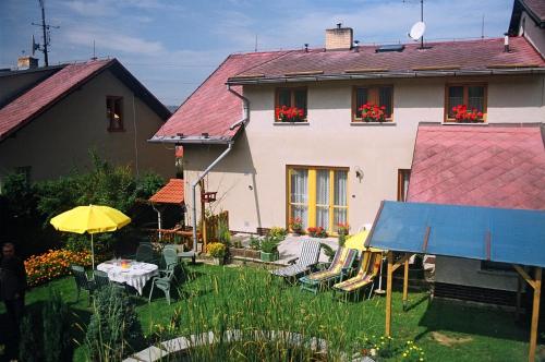 uma casa com um quintal com mesas e cadeiras em Penzion Gerta em Český Krumlov