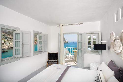 a white room with a bed and a view of the ocean at Blue Sand Boutique Hotel & Suites in Agali