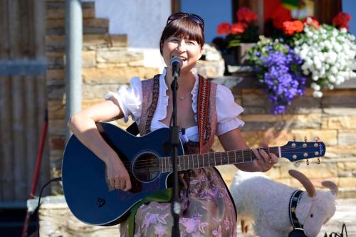 a woman playing a guitar with a microphone at Biobauernhof Gehrnerhof am Arlberg in Warth am Arlberg