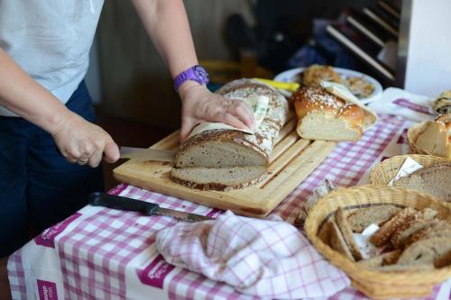 a person cutting a loaf of bread on a cutting board at Biobauernhof Gehrnerhof am Arlberg in Warth am Arlberg