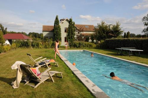 Lodge Saint-Hymer في Saint-Hymer: مجموعة من الناس يلعبون في حمام السباحة