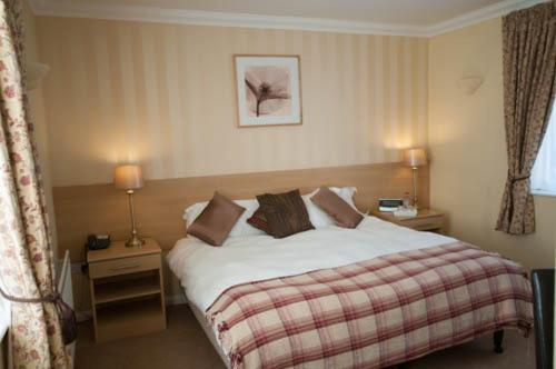 a bedroom with a bed and two tables with lamps at Byards Leap Lodge in Cranwell
