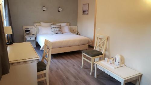 a small bedroom with a bed and two tables at Le Mas Du Colombier in Cadenet