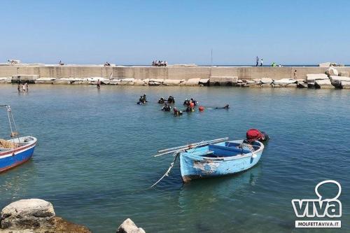 a small boat floating on top of a body of water at B&B Al Duomo Molfetta in Molfetta