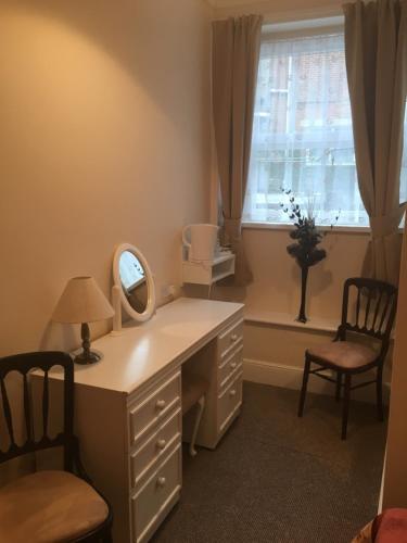 a dressing room with a vanity and a mirror and a window at Royal Pier in Sandown