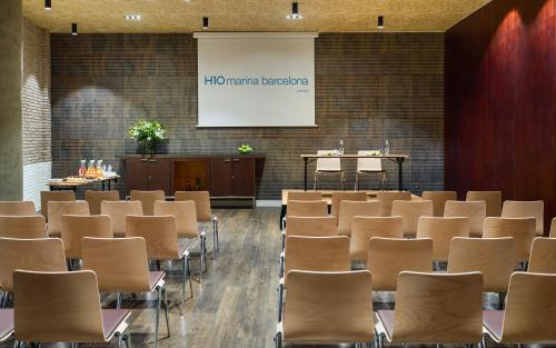 a conference room with chairs and a projector screen at H10 Marina Barcelona in Barcelona