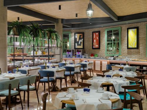 a dining room with white tables and chairs at H10 Marina Barcelona in Barcelona