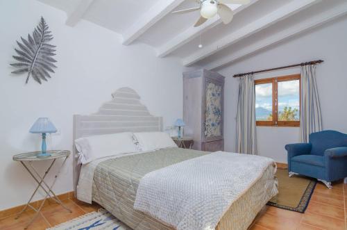 a bedroom with a bed and a blue chair at Can Rius in Muro