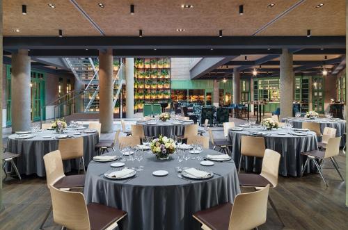 a banquet hall with round tables and chairs at H10 Marina Barcelona in Barcelona
