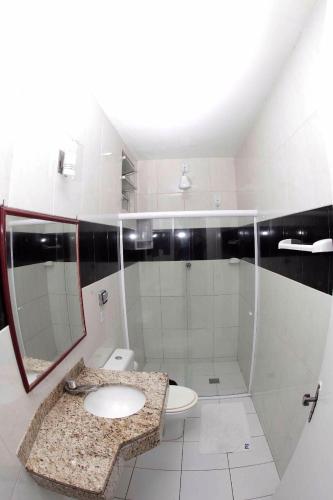a white bathroom with a sink and a toilet at Pousada Ferreira in Aracaju