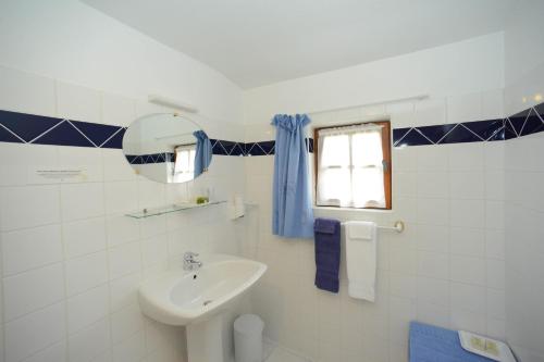 a white bathroom with a sink and a window at Logis Hôtel Restaurant Manoir De L'Acherie in Sainte-Cécile