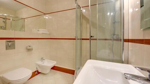 a bathroom with a shower and a toilet and a sink at Dom & House - Apartamenty Sea Towers in Gdynia