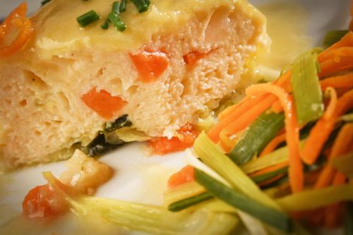 a close up of a plate of food with vegetables at Logis Hôtel Restaurant Manoir De L'Acherie in Sainte-Cécile