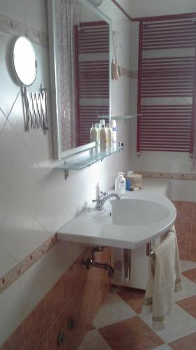 a bathroom with a white sink and a mirror at Appartamento Casa dei Frati in Magliano in Toscana