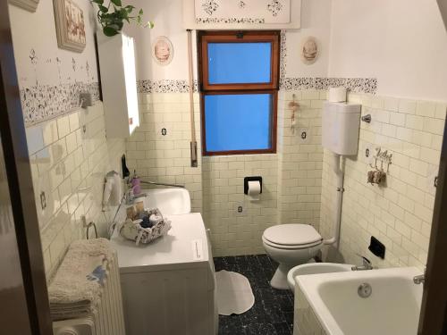 a white bathroom with a toilet and a sink at Bed & Breakfast Casa Marinella in Lenna
