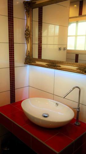 lavabo blanco en una encimera roja en el baño en Haus_Rosenrot, en Götemitz