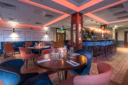 a restaurant with tables and chairs and a bar at Shipquay Boutique Hotel in Derry Londonderry