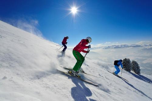 a group of people skiing down a snow covered slope at Appartementhaus Fuchs in Itter