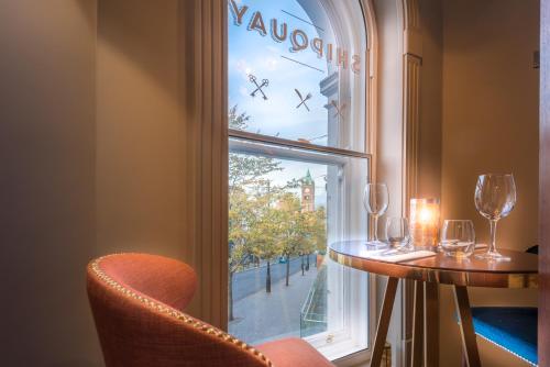 a table and chairs in front of a window at Shipquay Boutique Hotel in Derry Londonderry