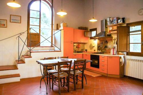 una cocina con mesa y sillas y una escalera en Agriturismo capanna delle Cozzole, en Castellina in Chianti