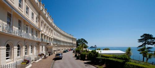 a street with cars parked on the side of a building at The Osborne Apartments in Torquay