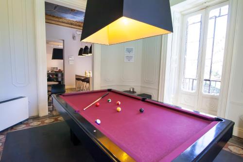 a pool table in a living room with ahibition at Toc Hostel Madrid in Madrid