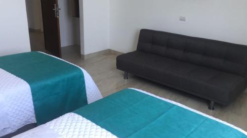a living room with a couch and a bed at Aquamarina Hotel in Manta