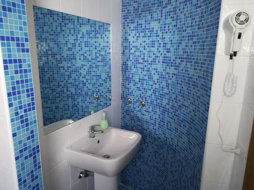 een blauw betegelde badkamer met een wastafel en een spiegel bij Residenza Skanderbeg in Montecilfone
